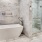 A beautiful white free-standing tub surrounded by tiled walls